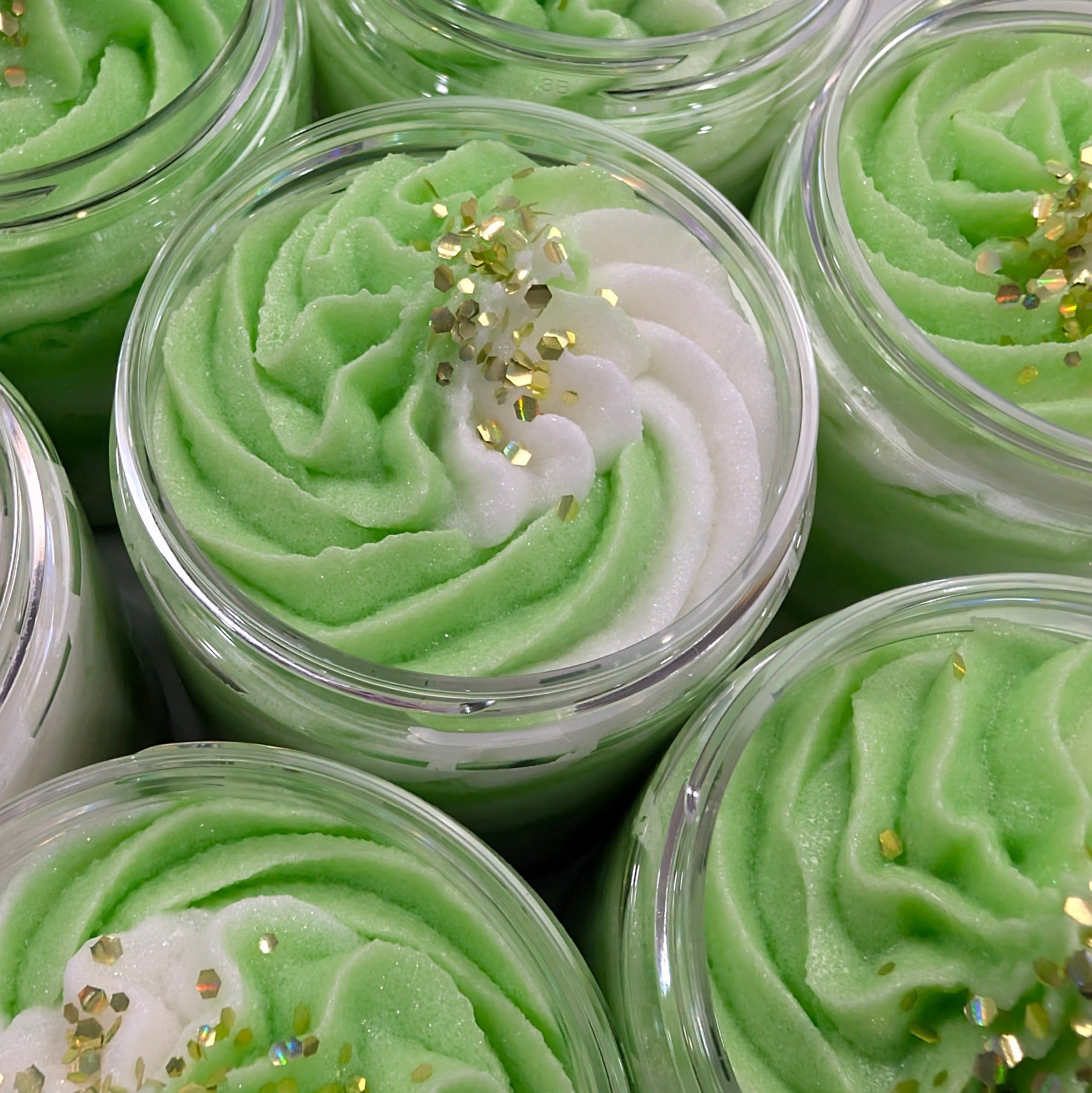 A jar of Cucumber Jade Foaming Sugar Scrub with a fresh blend of cucumber water, lemon zest, peony, and white musk. Gently exfoliates and hydrates for smooth skin.