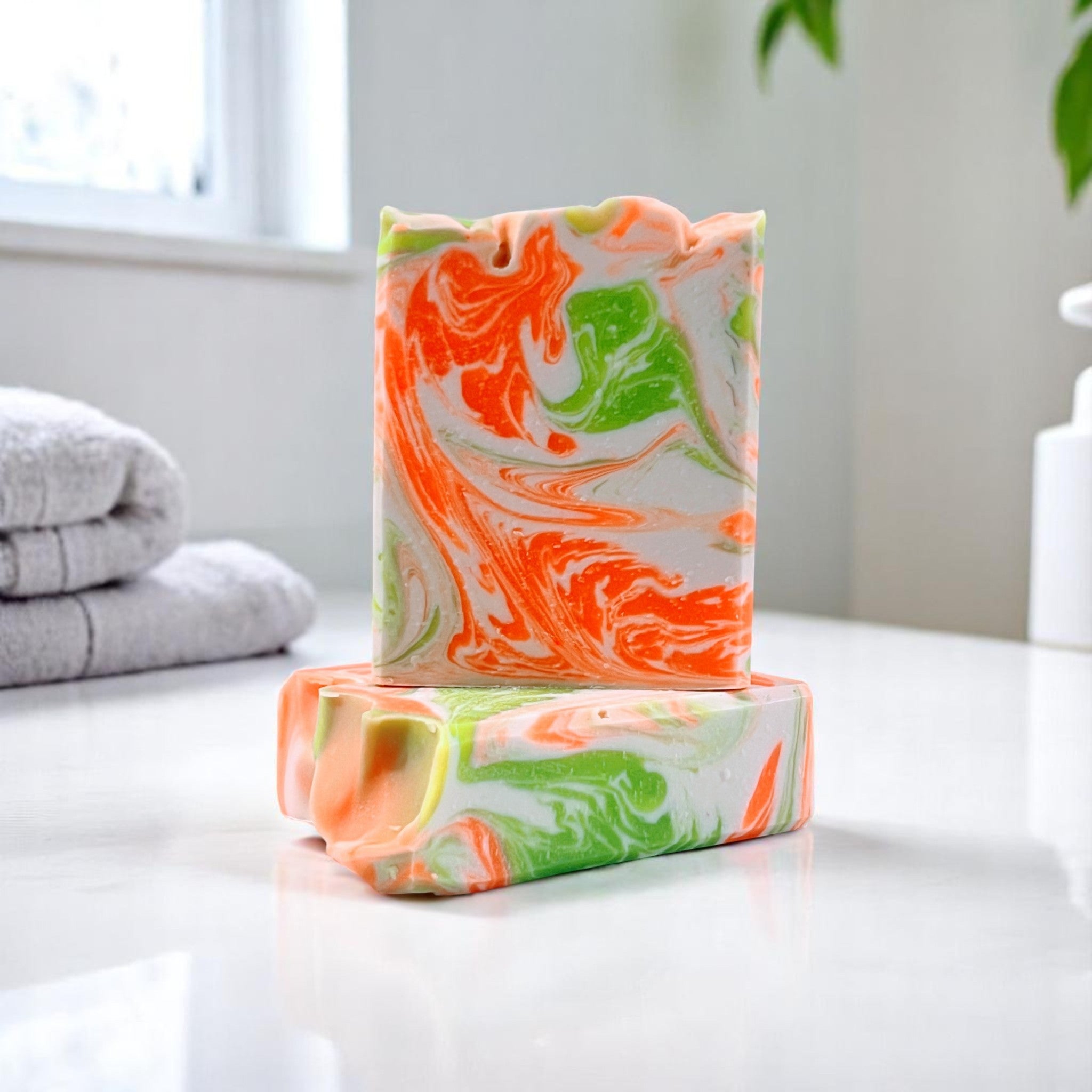 Handcrafted Peaches and Mint creamy soap bar with orange and green swirls.